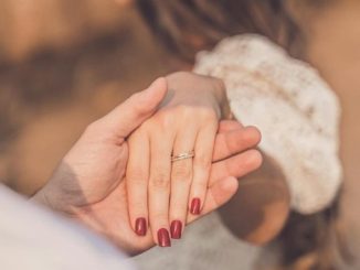 Čovek drži za ruku ženu koja mu je okrenuta leđima.