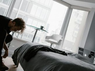 Čovek sedi na stolici i vezuje pertle